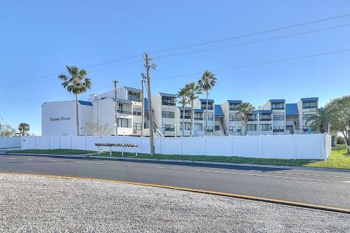 an empty street in front of a building with palm trees at Fairways #204 in Padre Island