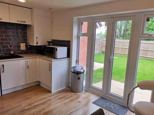 a kitchen with a sink and a microwave at Langley Haven - 3 BR House in Kent