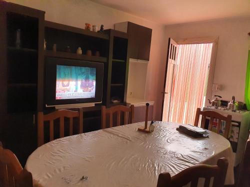 ein Esszimmer mit einem Tisch und einem TV in der Unterkunft Depto Dolores in Dolores