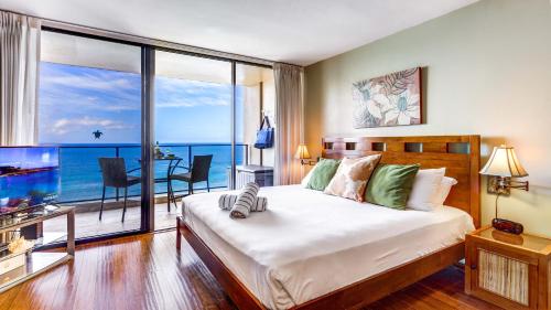 a bedroom with a bed with a view of the ocean at Maui Westside Presents: Mahana 1003 in Lahaina