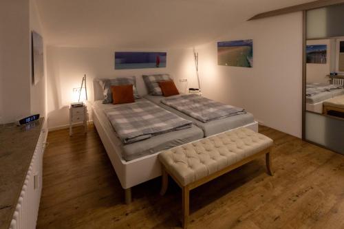 a bedroom with two beds and a bench in it at Ferienwohnung Moritz in Oberstaufen