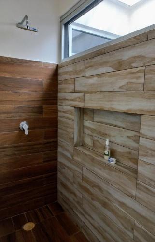 a bathroom with wooden walls and a window at MODERNO DEPARTAMENTO EN EL CENTRO in Tulum