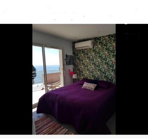 a bedroom with a purple bed with a view of the ocean at Vue mer.Tranquilité.Cap d'Ail à 10 mn de MONACO in Cap d'Ail