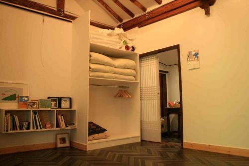 um quarto com um armário com toalhas nas prateleiras em TTOL LANG Cottage Jeonju Hanok Village em Jeonju