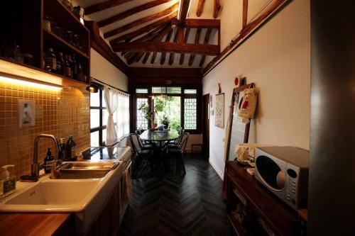 uma cozinha com um lavatório e uma mesa em TTOL LANG Cottage Jeonju Hanok Village em Jeonju