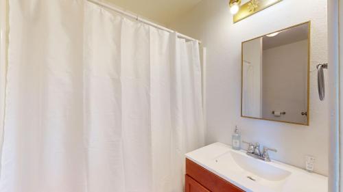 uma casa de banho com uma cortina de chuveiro branca e um lavatório. em Comfy Guesthouse in Yelm em Yelm