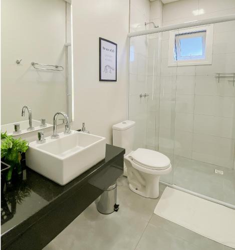 a bathroom with a sink and a toilet and a shower at Apto temático Dinossauros in Pomerode