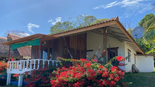 una pequeña casa con flores delante en Casa Iguana, en Las Tablas