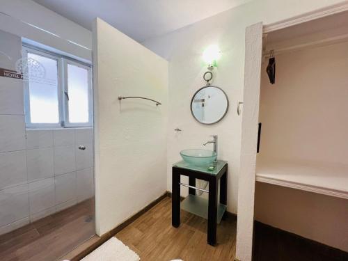 La salle de bains est pourvue d'un lavabo et d'un miroir sur une table. dans l'établissement Hotel Parador Vernal, à Bernal