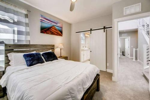 a bedroom with a large white bed with blue pillows at Luxury Oasis! in Denver