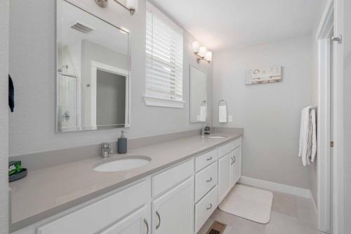a white bathroom with a sink and a mirror at Luxury Oasis! in Denver