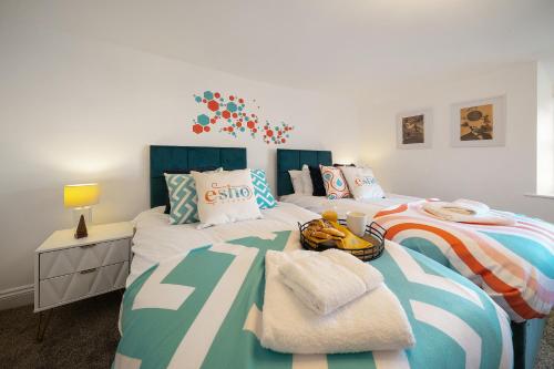 a bedroom with two twin beds and a desk at Cotswolds- 2 bed flat in 18th Century building, town centre with Smart TV - Esho Stays in Cirencester