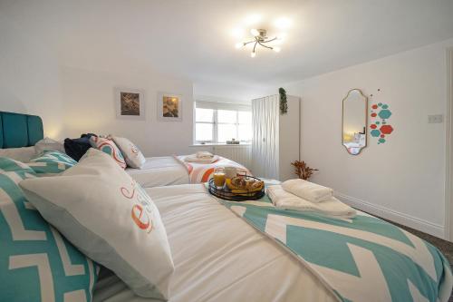 a room with a couch with pillows on it at Cotswolds- 2 bed flat in 18th Century building, town centre with Smart TV - Esho Stays in Cirencester