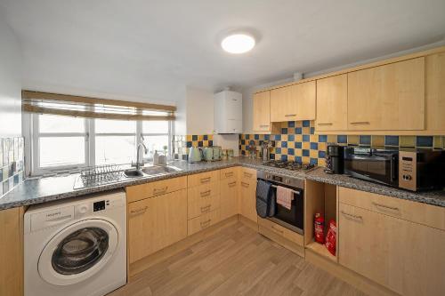 a kitchen with a washer and a washing machine at Cotswolds- 2 bed flat in 18th Century building, town centre with Smart TV - Esho Stays in Cirencester
