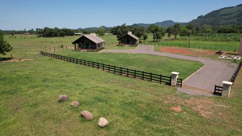 a large field with a fence and a building at Vicença Glamping in Praia Grande