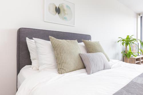 een bed met witte lakens en kussens in een slaapkamer bij Luxurious loft w-view walk city Center Delft New XL Apartment in Delft