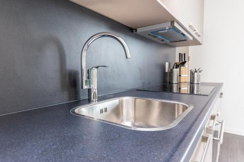 a kitchen with a stainless steel sink in a counter at Luxurious loft w-view walk city Center Delft New XL Apartment in Delft