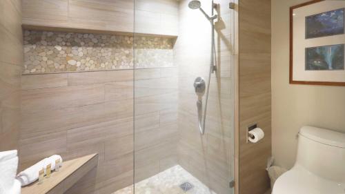 La salle de bains est pourvue d'une douche avec une porte en verre. dans l'établissement Maui Westside Presents: Whaler 420 - Best location in Kaanapali beach, à Lahaina