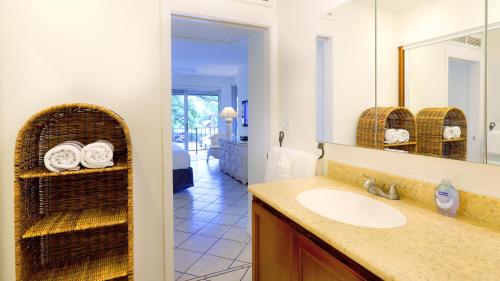 W łazience znajduje się umywalka i lustro. w obiekcie Maui Eldorado B200-Large lanai w/ocean/golf course views w mieście Lahaina