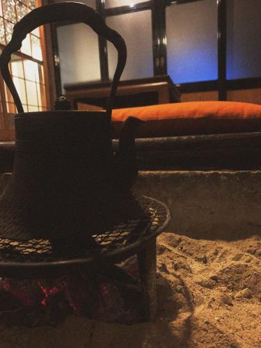 a black tea kettle sitting on a table next to a bed at 囲炉裏町家Guesthouse FUJITA 一棟貸切 villa 無料駐車場 in Hakusan