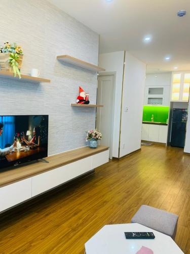 uma sala de estar com uma televisão de ecrã plano na parede em Du lịch Quy Nhơn-căn hộ viêw biển 4 em Quy Nhon