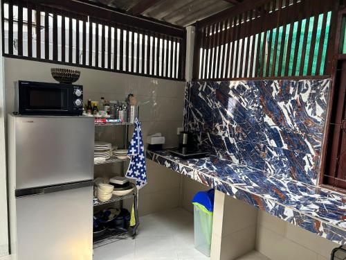 a kitchen with a counter with a refrigerator and a microwave at Cozy villa in Chiangmai old town in Chiang Mai