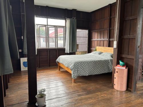 a bedroom with a bed and a large window at Cozy villa in Chiangmai old town in Chiang Mai