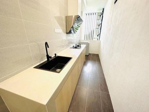 a kitchen with a sink and a counter top at Kuching BDC Saradise Rex Apartment in Kuching