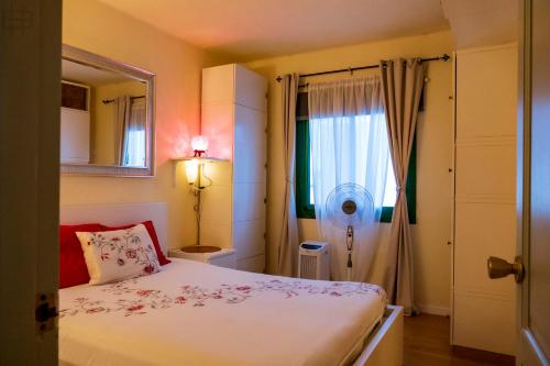a small bedroom with a bed and a window at Casa Su, precioso apartamento en complejo con piscina in Puerto del Carmen