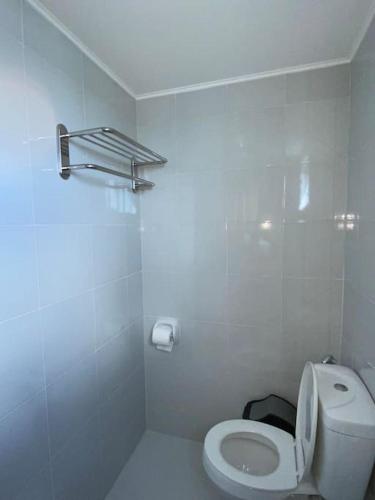 a white bathroom with a toilet and a towel rack at Scenic Lake Sunset View in Iloilo City