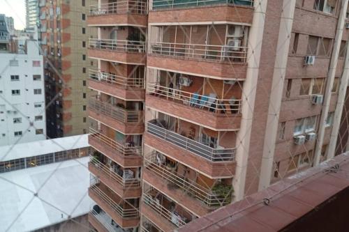 un edificio alto con balcones a un lado. en BOULEVARD OLLEROS en Buenos Aires