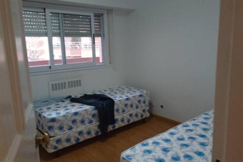 Habitación con 2 camas individuales y ventana. en BOULEVARD OLLEROS en Buenos Aires