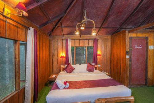 1 dormitorio con 2 camas en una habitación con paredes de madera en Nature Zone Jungle Resort, en Munnar