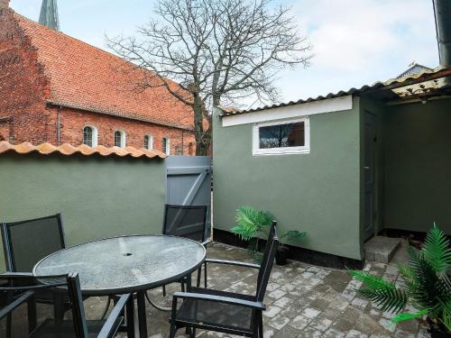 a patio with a table and chairs and a building at 4 person holiday home in Rudkøbing-By Traum in Rudkøbing