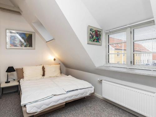 a white bedroom with a bed and a window at 4 person holiday home in Rudkøbing-By Traum in Rudkøbing