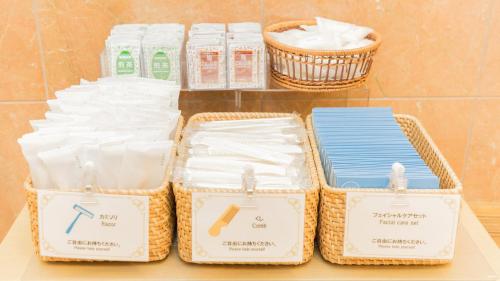 three baskets of toiletries sitting on a shelf in a bathroom at Toyoko Inn Imba Nihon-idai Ekimae in Inzai