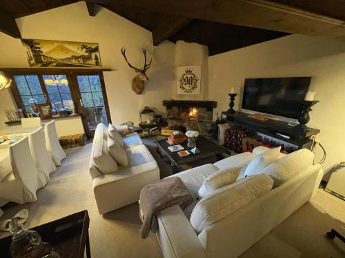 a living room with white couches and a fireplace at Chalet OG Harfe in Davos