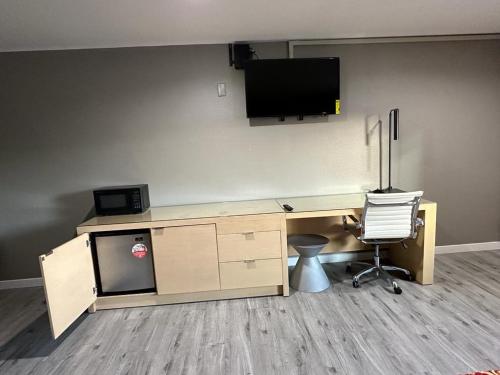ein Büro mit einem Schreibtisch und einem TV an der Wand in der Unterkunft Stay Inn Motel in Harbor City