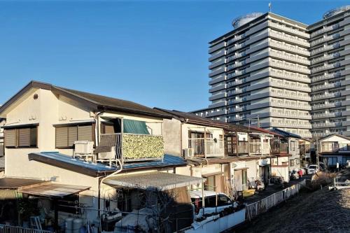 a large building next to a large apartment building at 江ノ島に近い富士山も眺める湘南の丘のヴィラーーー日本スタイルを体験できるTatami Room in Fujisawa