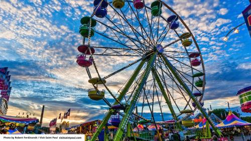 a ferris wheel at a carnival with a cloudy sky at InterContinental St. Paul Riverfront by IHG in Saint Paul