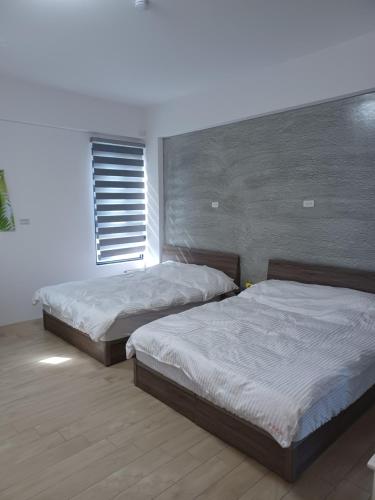 1 dormitorio con 2 camas y ventana en Stone Spring B&B en Magong