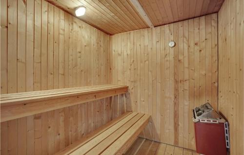 a wooden sauna with a bench and a trash can at Cozy Home In Hals With Sauna in Hals