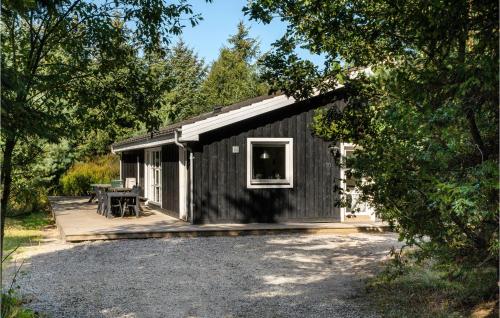 a black cabin with a porch and a patio at Cozy Home In Hals With Sauna in Hals