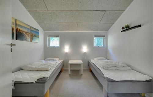 two beds in a small room with a table at Cozy Home In Hals With Sauna in Hals