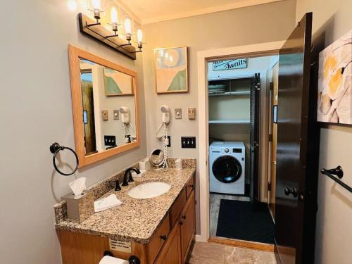 ein Badezimmer mit einem Waschbecken und einer Waschmaschine in der Unterkunft Attitash Mountain Village Studio - Slope View - Ski - NEWLY RENOVATED in Bartlett