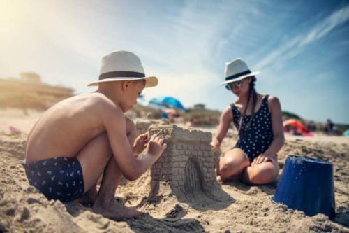 a man and woman playing with a sand castle on the beach at The Lily Pad Boatel Houseboat in Savanna