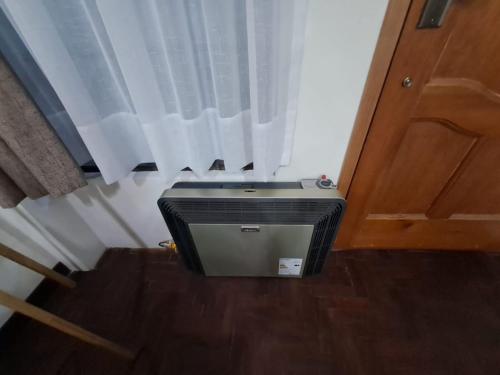 un televisor sentado en el suelo junto a una puerta en Bonito departamento Sopocachi centro, en La Paz