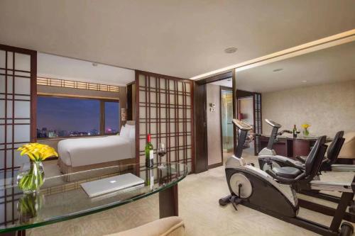 a room with a gym with a bed and a treadmill at The Garden Hotel Guangzhou in Guangzhou