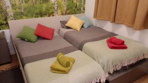 3 camas con almohadas de diferentes colores. en Apartamento Centro Histórico I, en Málaga