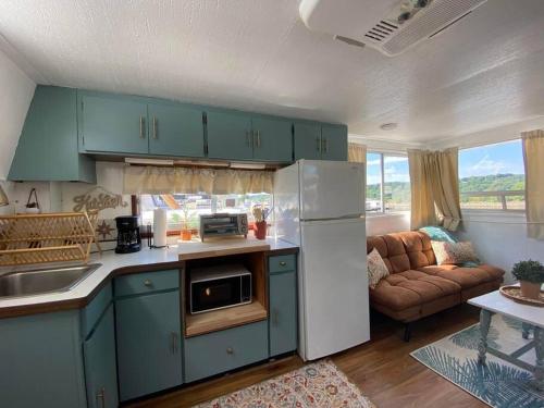 a kitchen with blue cabinets and a couch in a living room at Unique and Serene Sunset Houseboat for 4 in Savanna